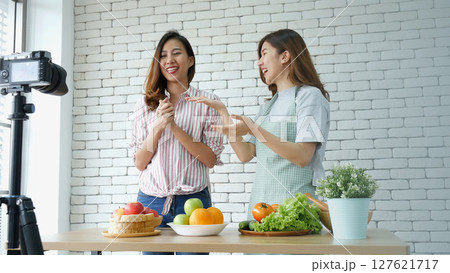 Two Asian influencer vlogger live review healthy lifestyle together. Two Young Women Friends blogger vlog Happy Lifestyle greeting Live Streaming. Vlog two women talk social media say hello broadcast 127621717