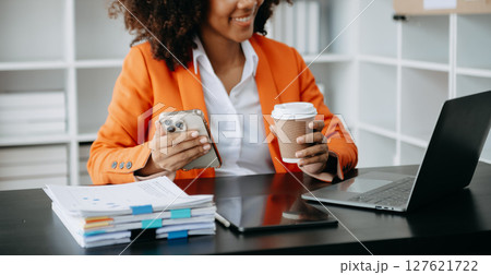 Successful African Businesswoman Analyzing Finance on Tablet and Laptop at modern Office Desk tax, 127621722