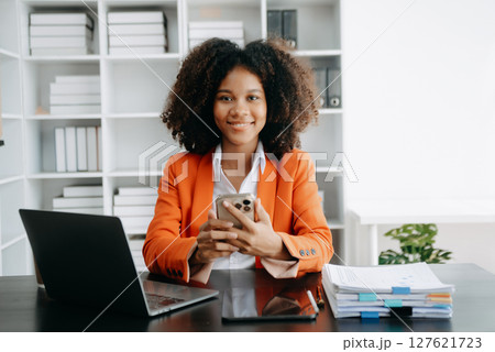 Successful African Businesswoman Analyzing Finance on Tablet and Laptop at modern Office Desk tax, Successful African Businesswoman Analyzing Finance on Tablet and Laptop at modern Office Desk tax, 127621723