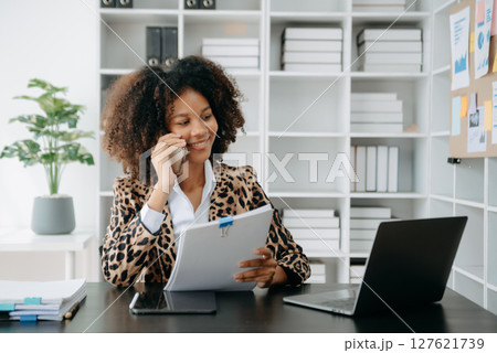 Successful African Businesswoman Analyzing Finance on Tablet and Laptop at modern Office Desk tax, Successful African Businesswoman Analyzing Finance on Tablet and Laptop at modern Office Desk tax, 127621739