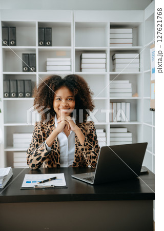 Successful African Businesswoman Analyzing Finance on Tablet and Laptop at modern Office Desk tax, 127621768