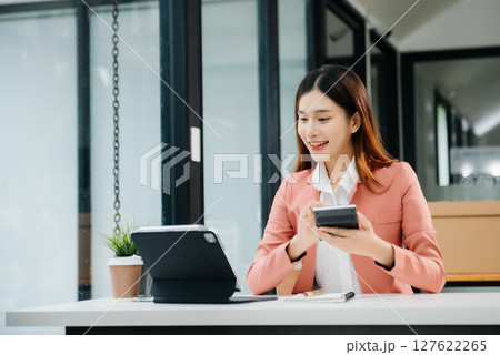 Asian businesswoman working in the office with working notepad, tablet and laptop documents 127622265