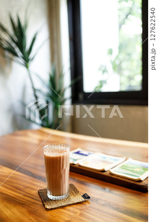 Cup of delicious iced chocolate on wooden table background by the window. 127622540