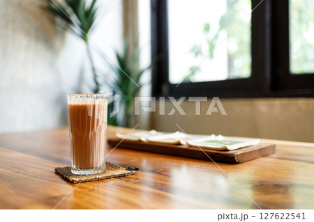 Cup of delicious iced chocolate on wooden table background by the window. 127622541
