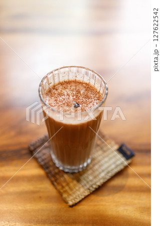 Cup of delicious iced chocolate on wooden table background by the window. 127622542