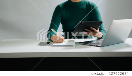 Close-up view of young professional businessman writing his idea concepts on notebook while working on his project 127622684