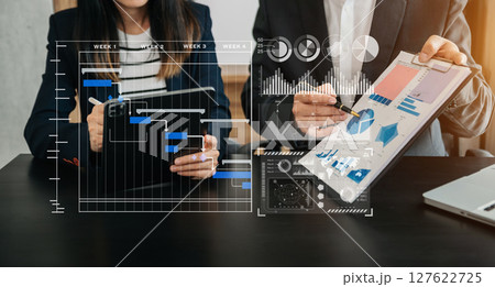 Business team hand Project manager working and update tasks and Gantt chart scheduling virtual diagram.with smart phone, tablet and laptop Business team hand Project manager working and update tasks and Gantt chart scheduling virtual diagram.with smart phone, tablet and laptop 127622725