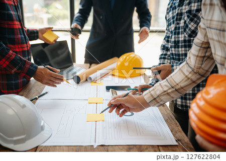 Engineer teams meeting working together wear worker helmets hardhat on construction site in modern city. Engineer teams meeting working together wear worker helmets hardhat on construction site in modern city. 127622804
