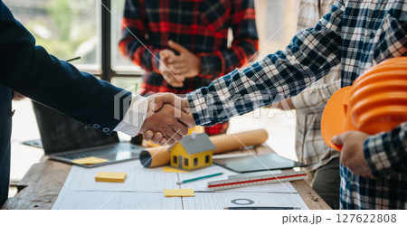 Creative architect projecting on the big drawings in the dark loft office or cafe 127622808