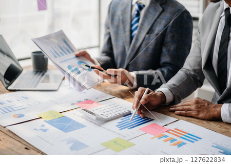 Business People Talking Discussing with financial document data charts and graphs Team business meeting with smart phone and laptop and digital tablet computer Business People Talking Discussing with financial document data charts and graphs Team business meeting with smart phone and laptop and digital tablet computer 127622834