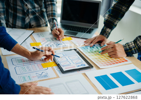 UX developer and ui designer brainstorming about mobile app interface wireframe design with customer breif and color code at modern office. 127622868