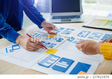 View of UI developer team brainstorming on their project with laptop, smartphone and digital tablet. Creative digital development agency. View of UI developer team brainstorming on their project with laptop, smartphone and digital tablet. Creative digital development agency. 127622870