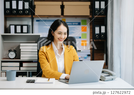 Portrait of female office businesswoman startup daydreaming about her work, startup and working with laptop on office desk in office 127622972