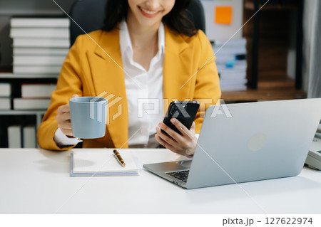 Portrait of female office businesswoman startup daydreaming about her work, startup and working with laptop on office desk in office 127622974