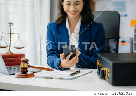 justice and law concept. Asian Female judge in a courtroom on wooden table and Counselor or Male lawyer working in modern office. justice and law concept. Asian Female judge in a courtroom on wooden table and Counselor or Male lawyer working in modern office. 127623015