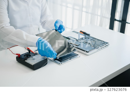 Electronics technician, electronic engineering electronic repair,electronics measuring and testing, repair and maintenance concepts.uses a voltage meter to check and upgrade in shop 127623076