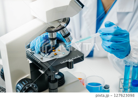 Modern medical research laboratory. female scientist working with micro pipettes analyzing biochemical samples, advanced science chemical laboratory Modern medical research laboratory. female scientist working with micro pipettes analyzing biochemical samples, advanced science chemical laboratory 127623098