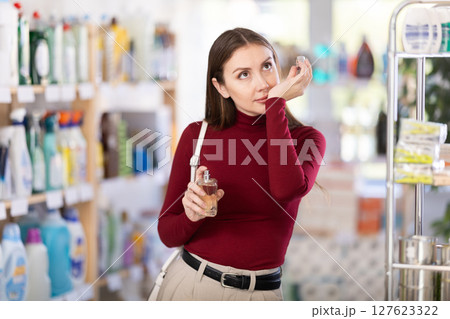 Young woman chooses perfume in store Young woman chooses perfume in store 127623322