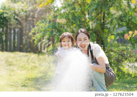 庭に水撒きをする親子 庭に水撒きをする親子 127623504