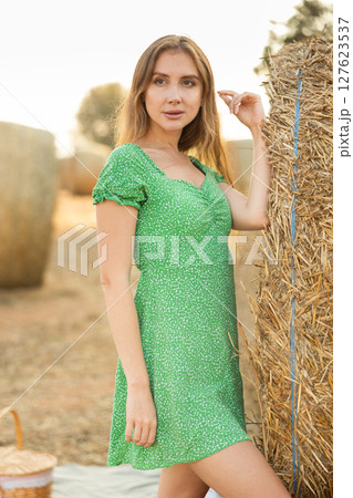 Young woman in dress standing during picnic Young woman in dress standing during picnic 127623537