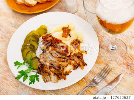 Fried pork served with potatoes and cucumber 127623627