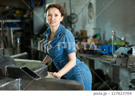 Portrait of confident female worker in workshop of metallurgical plant 127623704