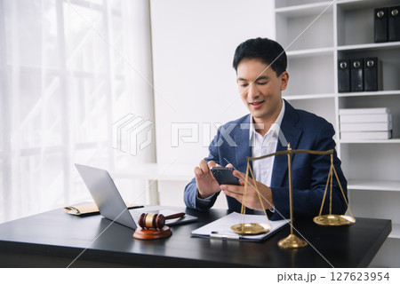 Attractive young lawyer in office Business man and lawyers discussing contract papers laptop and tablet with brass scale on desk in office. Attractive young lawyer in office Business man and lawyers discussing contract papers laptop and tablet with brass scale on desk in office. 127623954