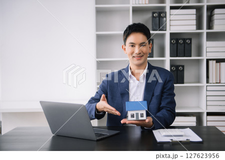 Asian man working with House model real estate agent and customer discussing for contract to buy house, insurance or loan real estate consult concerning mortgage loan offer 127623956