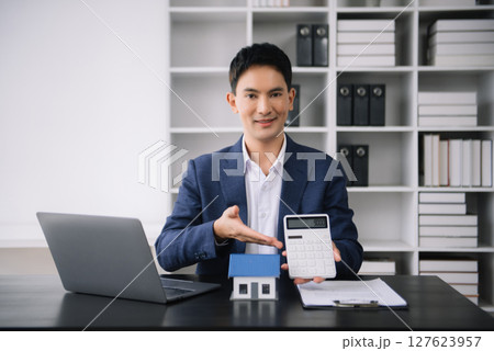 Asian man working with House model real estate agent and customer discussing for contract to buy house, insurance or loan real estate consult concerning mortgage loan offer 127623957