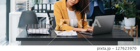 Businesswoman working in the office with working notepad, tablet and laptop documents 127623970