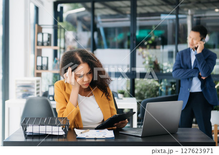 Businesswoman working in the office with working notepad, tablet and laptop documents Businesswoman working in the office with working notepad, tablet and laptop documents 127623971