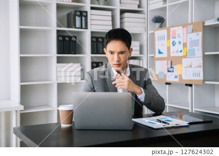 Asian business man is stressed, bored, and overthinking from working on a tablet at the modern office. 127624302