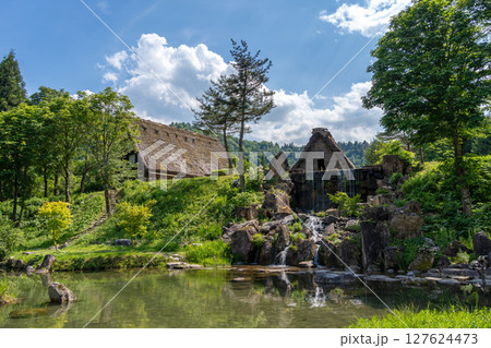 Traditional houses and waterfall pond in Shirakawa-go, Japan Traditional houses and waterfall pond in Shirakawa-go, Japan 127624473