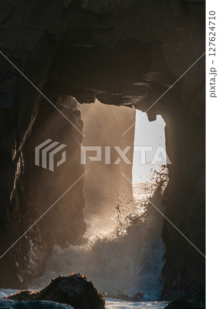 Setting sun peeping through keyhole arch 127624710