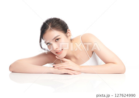 A beautiful young Asian woman with clean, fresh skin against a white background. Skincare, facial treatment, cosmetology, beauty, and spa. An elegant portrait of an Asian woman. 127624990