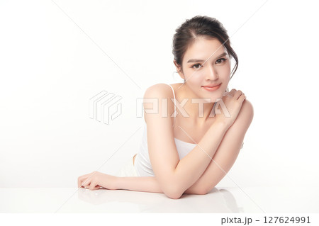 A beautiful young Asian woman with clean, fresh skin against a white background. Skincare, facial treatment, cosmetology, beauty, and spa. An elegant portrait of an Asian woman. 127624991
