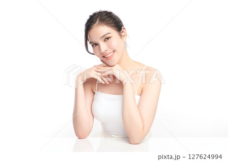 A beautiful young Asian woman with clean, fresh skin against a white background. Skincare, facial treatment, cosmetology, beauty, and spa. An elegant portrait of an Asian woman. 127624994