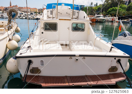 Small boats lined up at marina with modern coastal skyline in the background. Urban tourism, coastal life, and everyday boating in seaside European towns. Small boats lined up at marina with modern coastal skyline in the background. Urban tourism, coastal life, and everyday boating in seaside European towns. 127625063