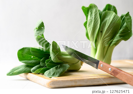 Organic Bok choy or Pak choi on cutting wooden board with kitchen knife, Fresh vegetable 127625471