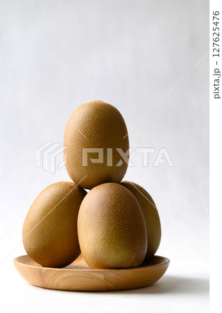 Fresh kiwi fruit on wooden plate with white background, Healthy fruit Fresh kiwi fruit on wooden plate with white background, Healthy fruit 127625476
