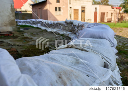 Sandbags stacked near house to protect from flood risk emergency Sandbags stacked near house to protect from flood risk emergency 127625846
