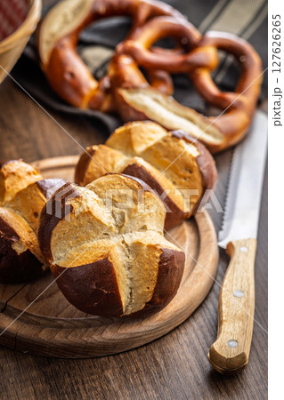 Crunchy bavarian buns on cutting board on wooden table. Crunchy bavarian buns on cutting board on wooden table. 127626265