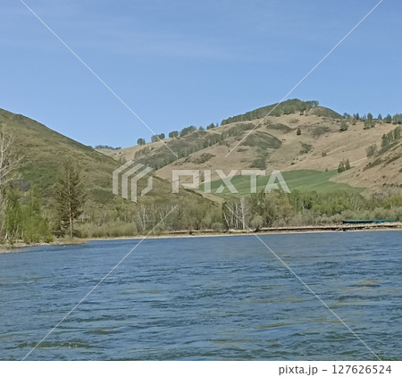 Picturesque Landscape Featuring a Tranquil River Flowing Through Rolling Hills and Lush Greenery Picturesque Landscape Featuring a Tranquil River Flowing Through Rolling Hills and Lush Greenery 127626524