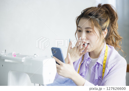 ミシンで裁縫する女性 127626600