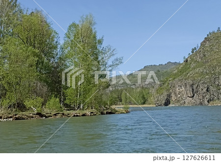 Idyllic River Scenery Verdant Forest Meets the Calm Waters of a Serene River Landscape. Idyllic River Scenery Verdant Forest Meets the Calm Waters of a Serene River Landscape. 127626611