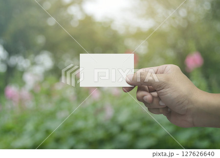 Man hand holding blank white business name card in fingers 127626640