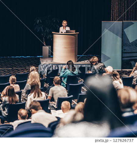 Female speaker giving a talk on corporate business conference. Unrecognizable people in audience at conference hall. Business and Entrepreneurship event Female speaker giving a talk on corporate business conference. Unrecognizable people in audience at conference hall. Business and Entrepreneurship event 127626737
