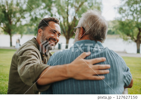 Happy dad and adult son enjoying peaceful afternoon outdoors 127627150