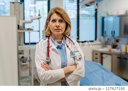 Portrait of female doctor standing in examination room. 127627180