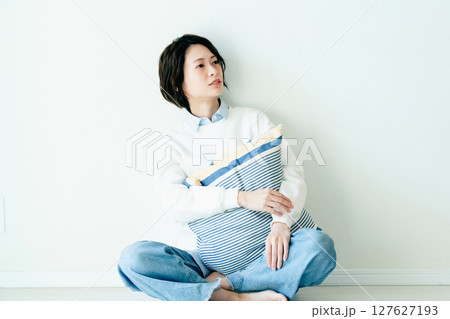 壁の前に座る若い女性 壁の前に座る若い女性 127627193